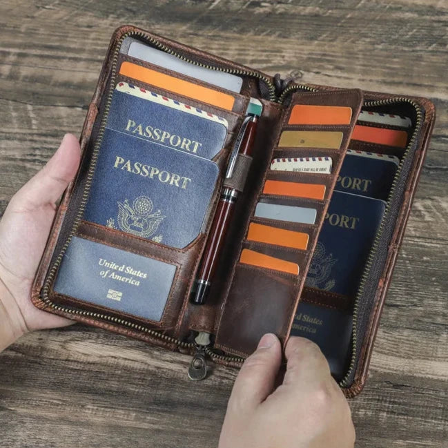 Brown top-grain leather passport wallet with RFID protection, holding multiple US passports, cards, and a pen.