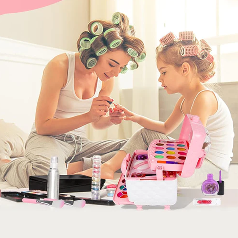 Mother and daughter with hair rollers play with a pink Princess Glamour makeup kit containing eyeshadow and polish.