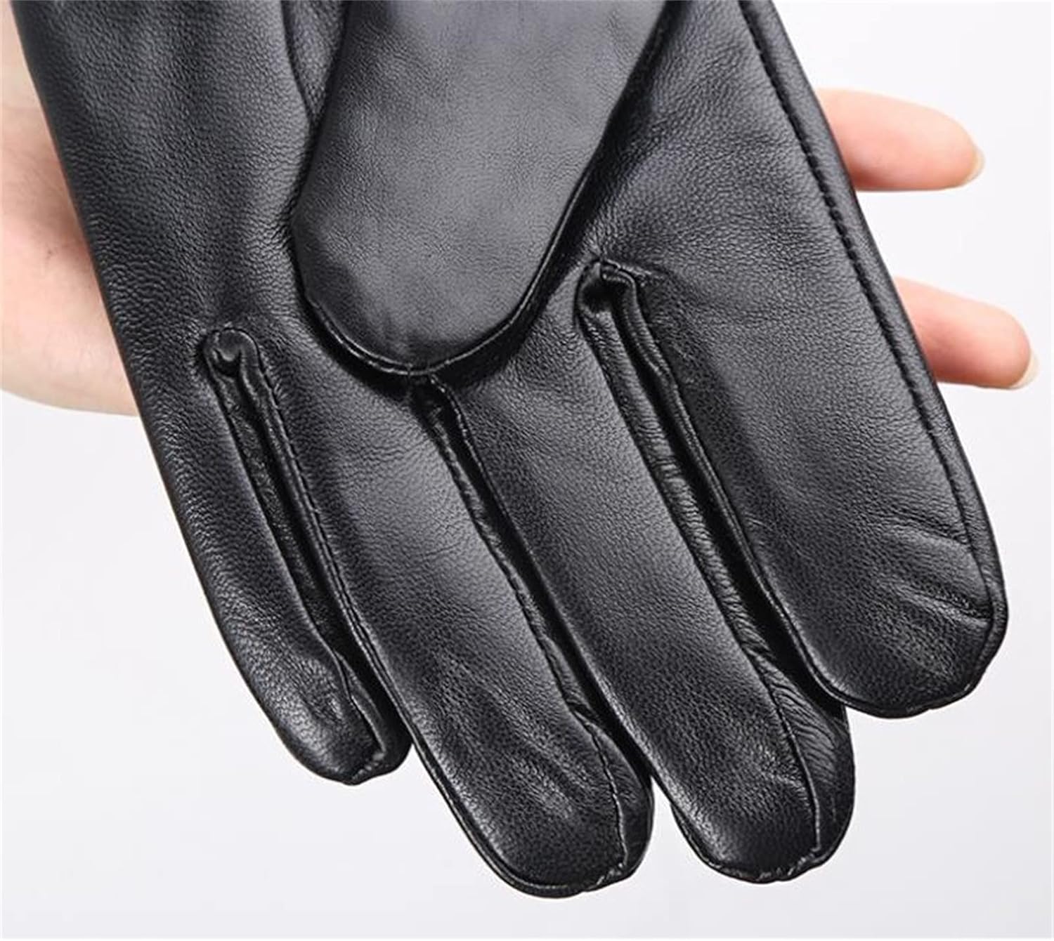 Fitlybuy RippleWarm black sheepskin winter glove being held, showcasing smooth leather texture and detailed stitching.