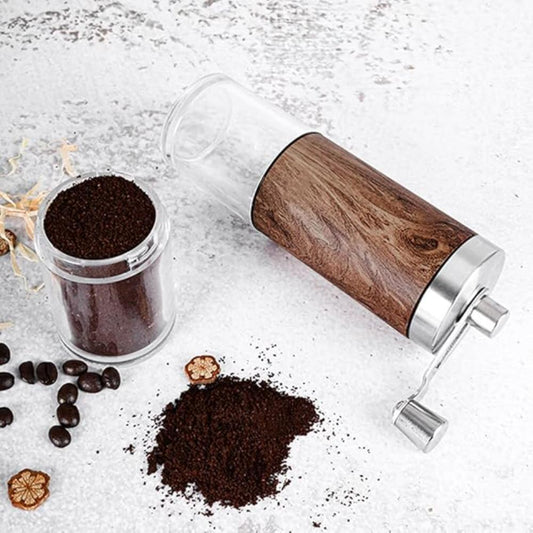 Fitlybuy Brewora wooden manual coffee grinder with metal handle and glass container, filled with ground coffee on table.