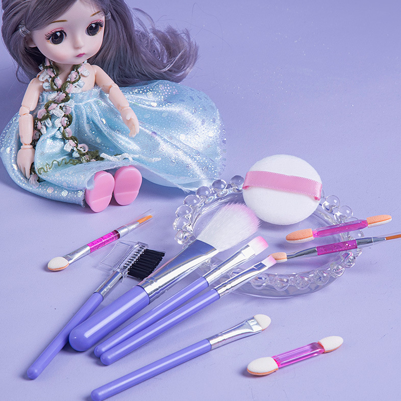 Fitlybuy kids' makeup set with purple brushes, applicator tools, and a puff, displayed near a doll in a blue dress.