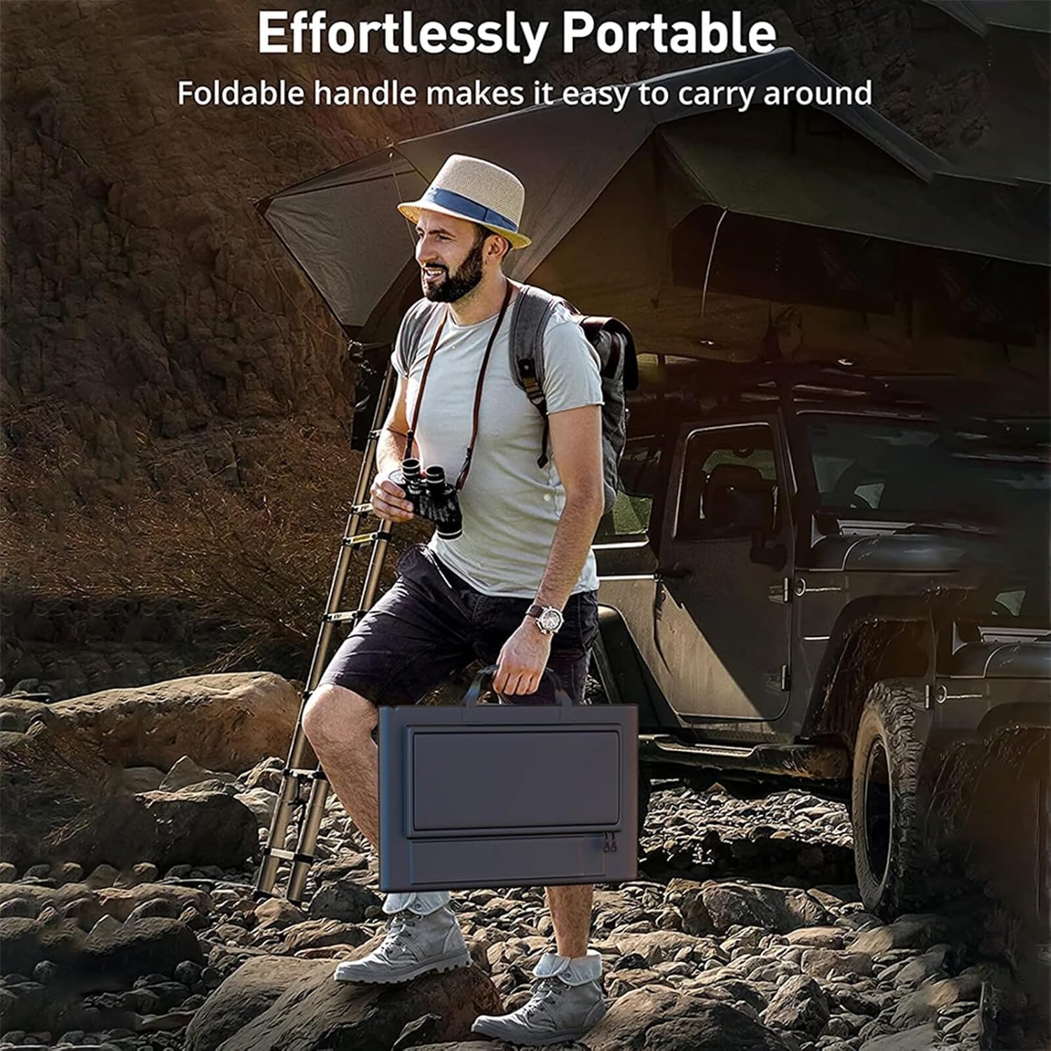 A man carries a black, foldable Fitlybuy SolaraX 1000W solar panel kit by a handle outdoors near an off-road vehicle.