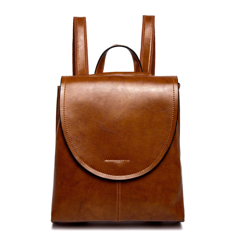 Fitlybuy brown leather backpack with a rounded flap closure, top handle, and adjustable shoulder straps.