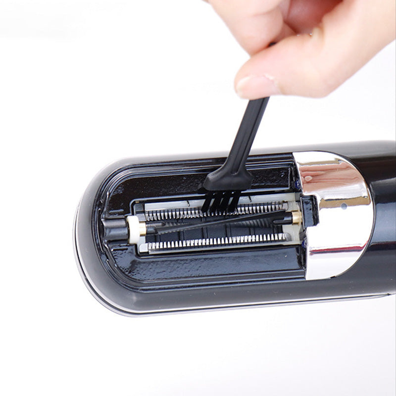 Hand uses a small brush to clean the blades of a black Fitlybuy automatic split-end hair trimmer.