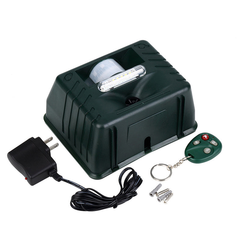 Green Fitlybuy ultrasonic woodpecker repeller with LED light, motion sensor, power adapter, remote, and mounting hardware.