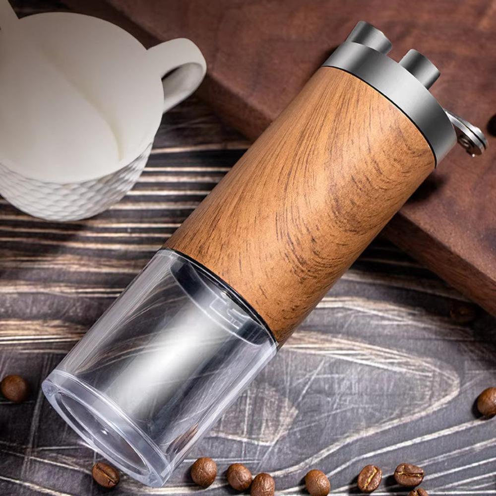 Fitlybuy Brewora wooden manual coffee grinder with clear base, metal top, and coffee beans on a rustic table.
