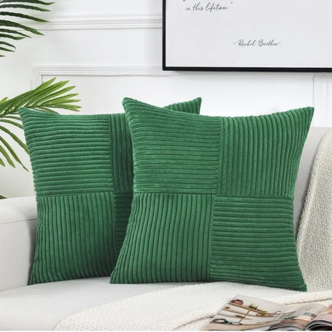 Two emerald green, corduroy-textured Fitlybuy Volyx square cushions on a white sofa, featuring a stylish paneled design.