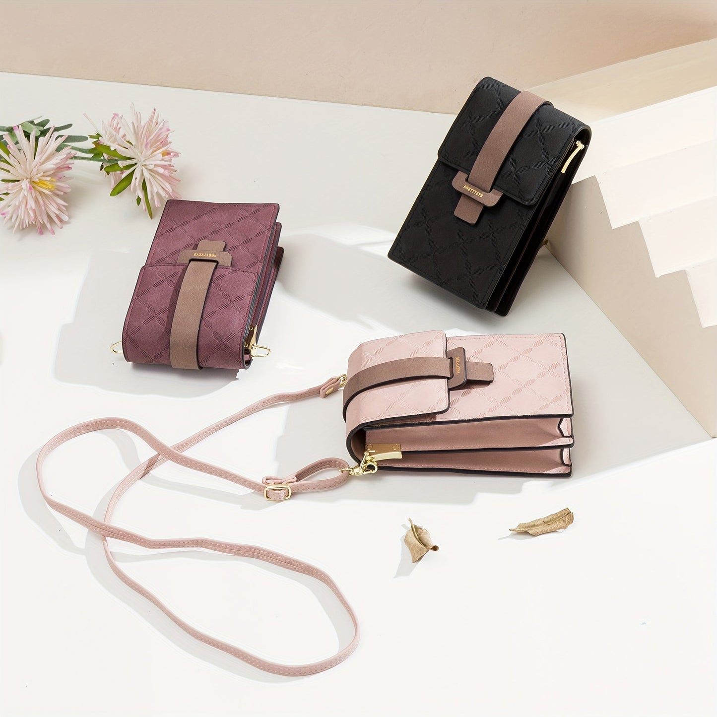 Three Fitlybuy Lily anti-theft crossbody bags in black, burgundy, and pink, each with a secure clasp on a floral print.