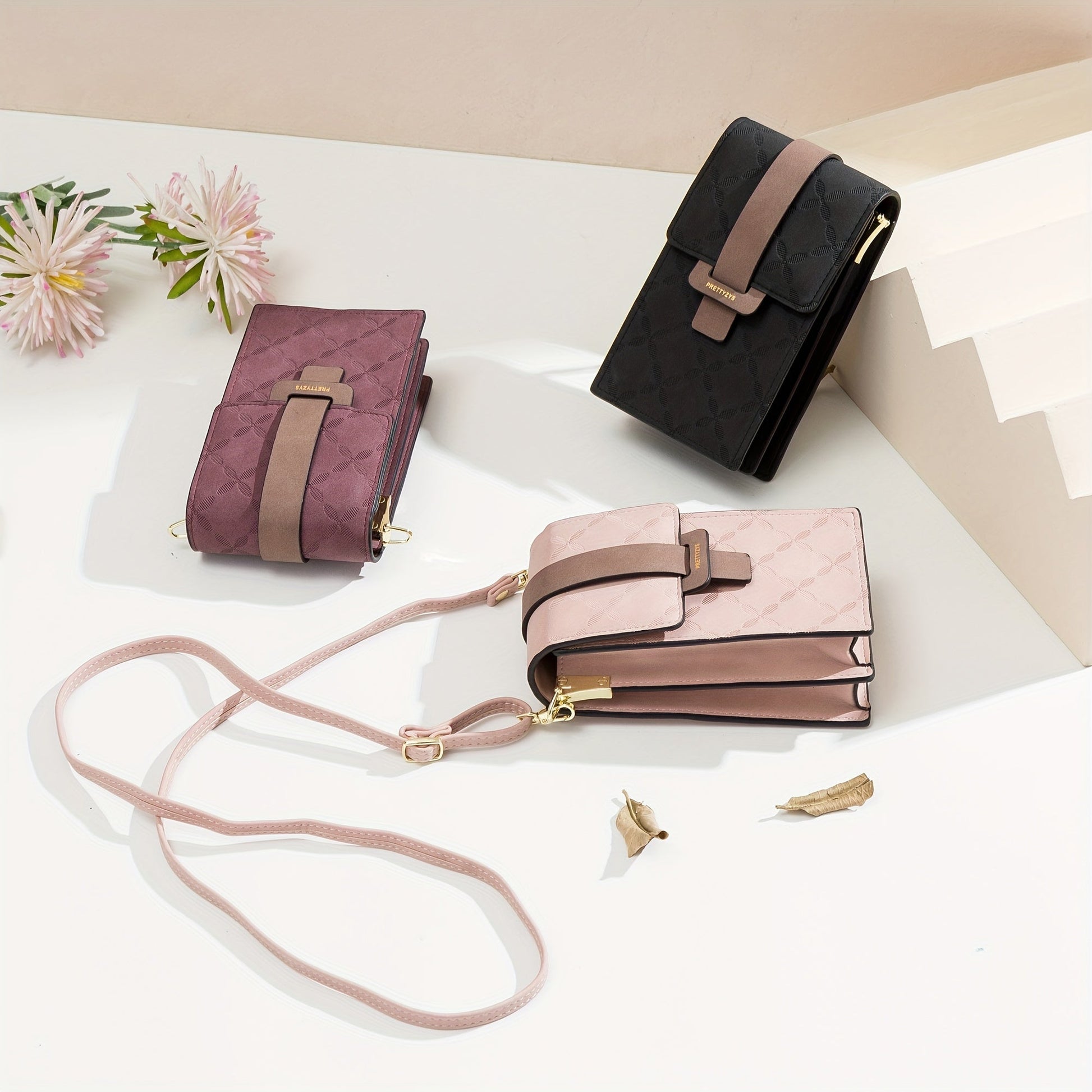 Three Fitlybuy Lily anti-theft crossbody bags in black, burgundy, and pink, each with a secure clasp on a floral print.