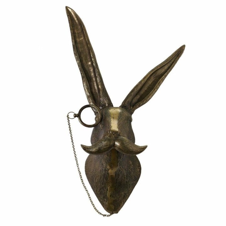 Bronze hare wall sculpture with a bushy mustache, monocle, and chain detail against a white background.