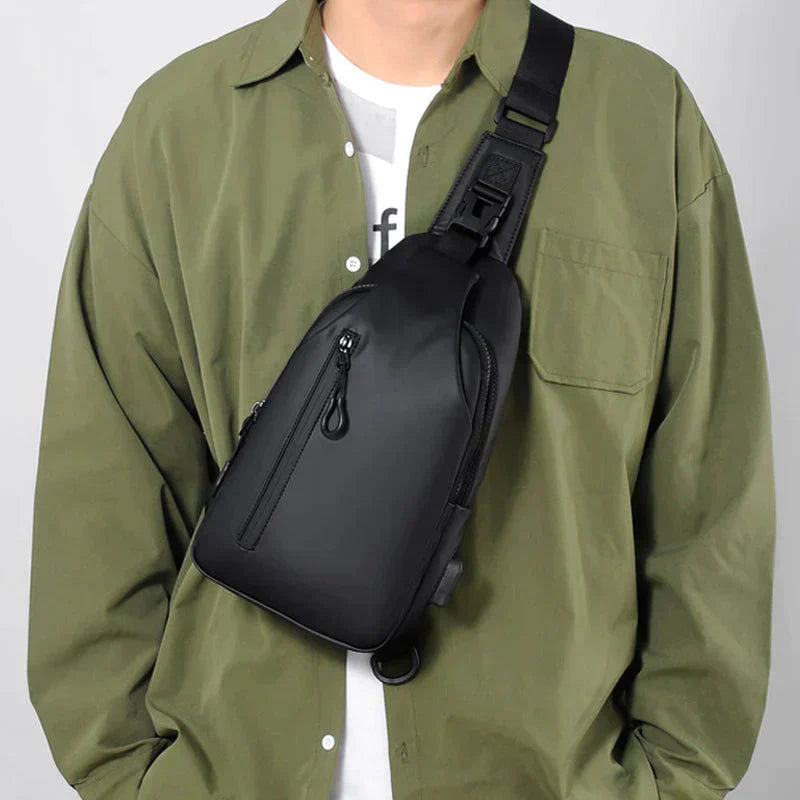 Black Fitlybuy waterproof anti-theft crossbody bag worn on a person in an olive green shirt.