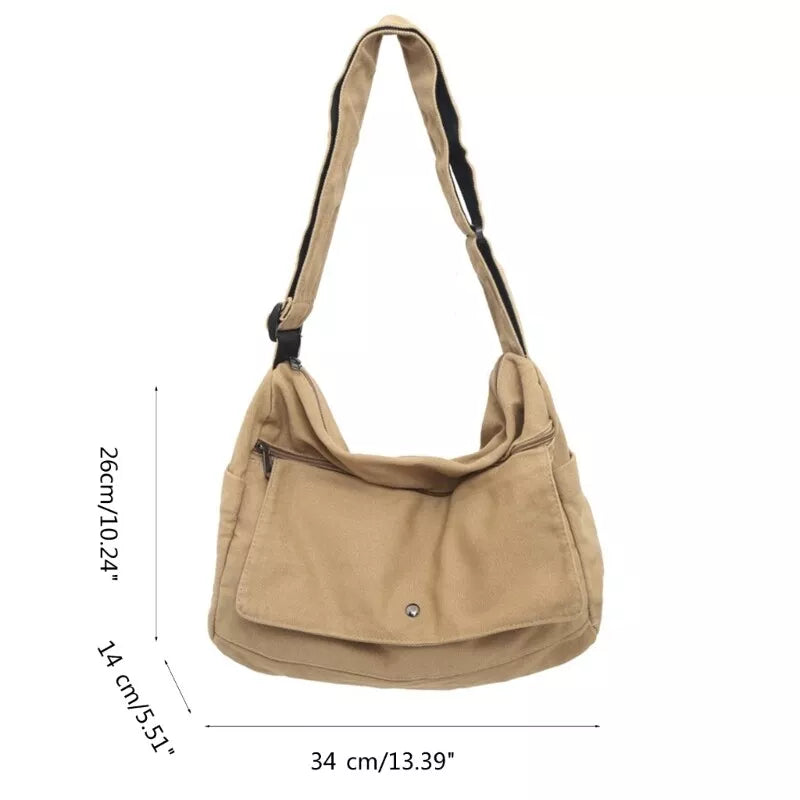 Tan canvas sling bag with adjustable strap, front flap pocket, and dimensions labeled in cm and inches on white background.