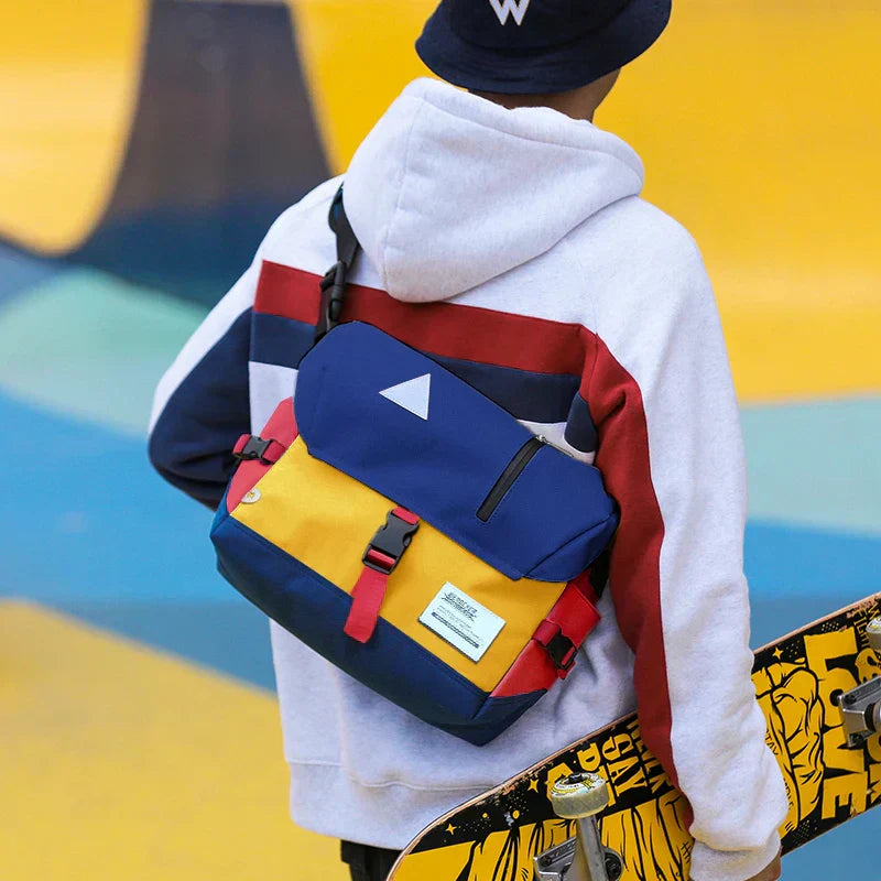 Person wearing a blue, yellow, and red water-resistant Fitlybuy crossbody messenger bag with a skateboard.