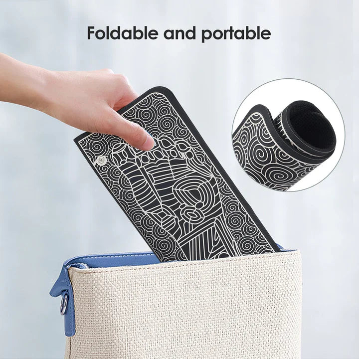 Hand holding a foldable, black and white pattern Fitlybuy EMS foot massage mat being placed into a small bag.