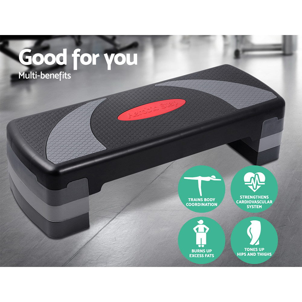 Fitlybuy 3-level black and grey aerobic step platform with anti-slip grip and health benefit icons on gym background.
