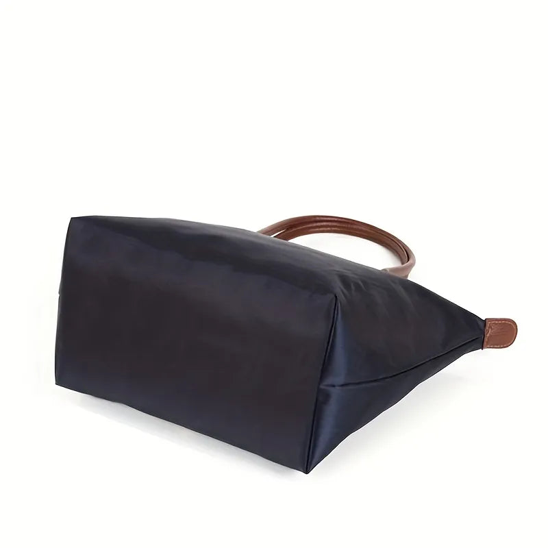 Fitlybuy navy blue spacious nylon tote handbag with brown leather-look handles, shown from a side angle on white.
