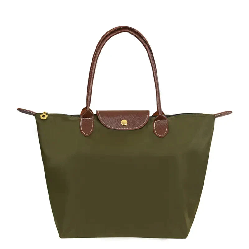 Olive green tote handbag with brown leather handles, a front flap with gold snap closure, and a floral zipper pull.