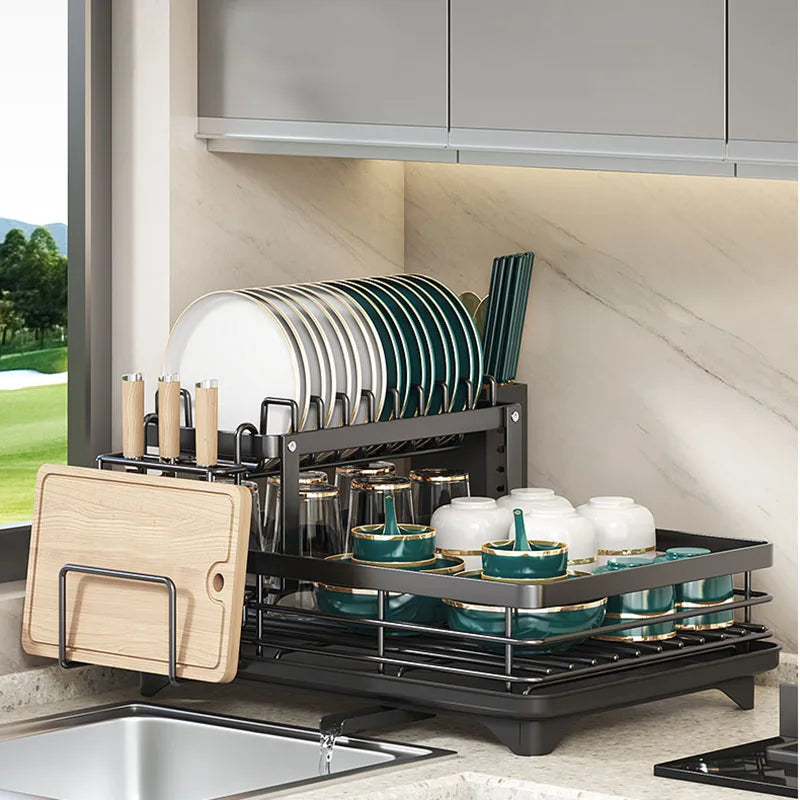 Fitlybuy black two-tier adjustable dish drying rack with a cutting board holder, shown filled on a kitchen countertop.
