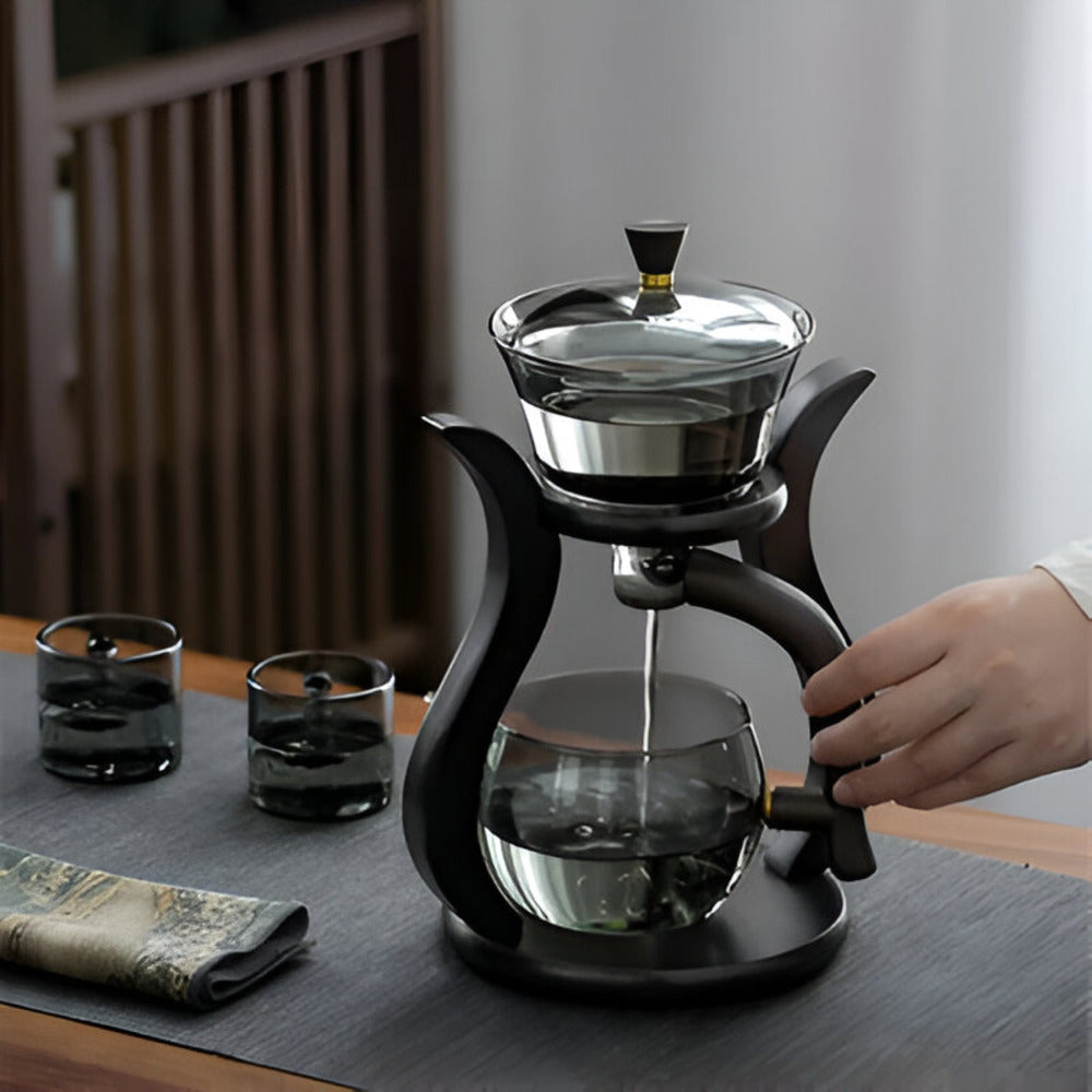 Fitlybuy magnetic glass teapot set with infuser on a black stand, featuring dark glass, drip-free design, and two cups.