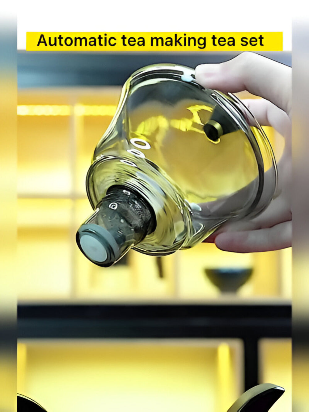 Fitlybuy clear glass magnetic teapot infuser held by hand, demonstrating automatic drip-free loose leaf tea brewing.
