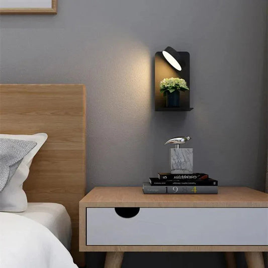 Fitlybuy BrightSpot wall lamp with rotating LED light and shelf holding a plant, mounted above a wooden nightstand.