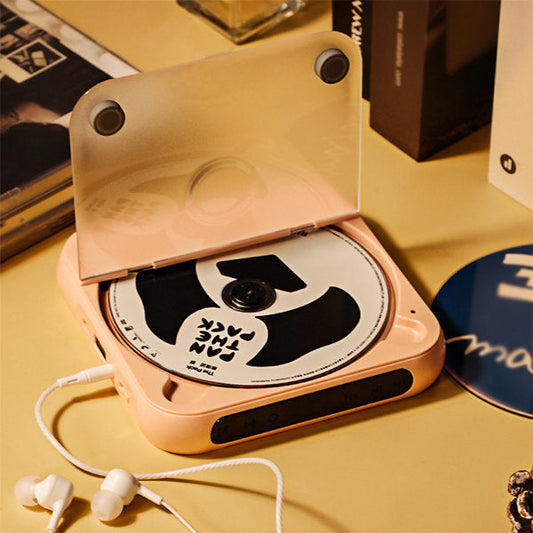 Fitlybuy PortaTune portable peach CD player with open lid, CD inserted, AUX cord, and earbuds on a table.