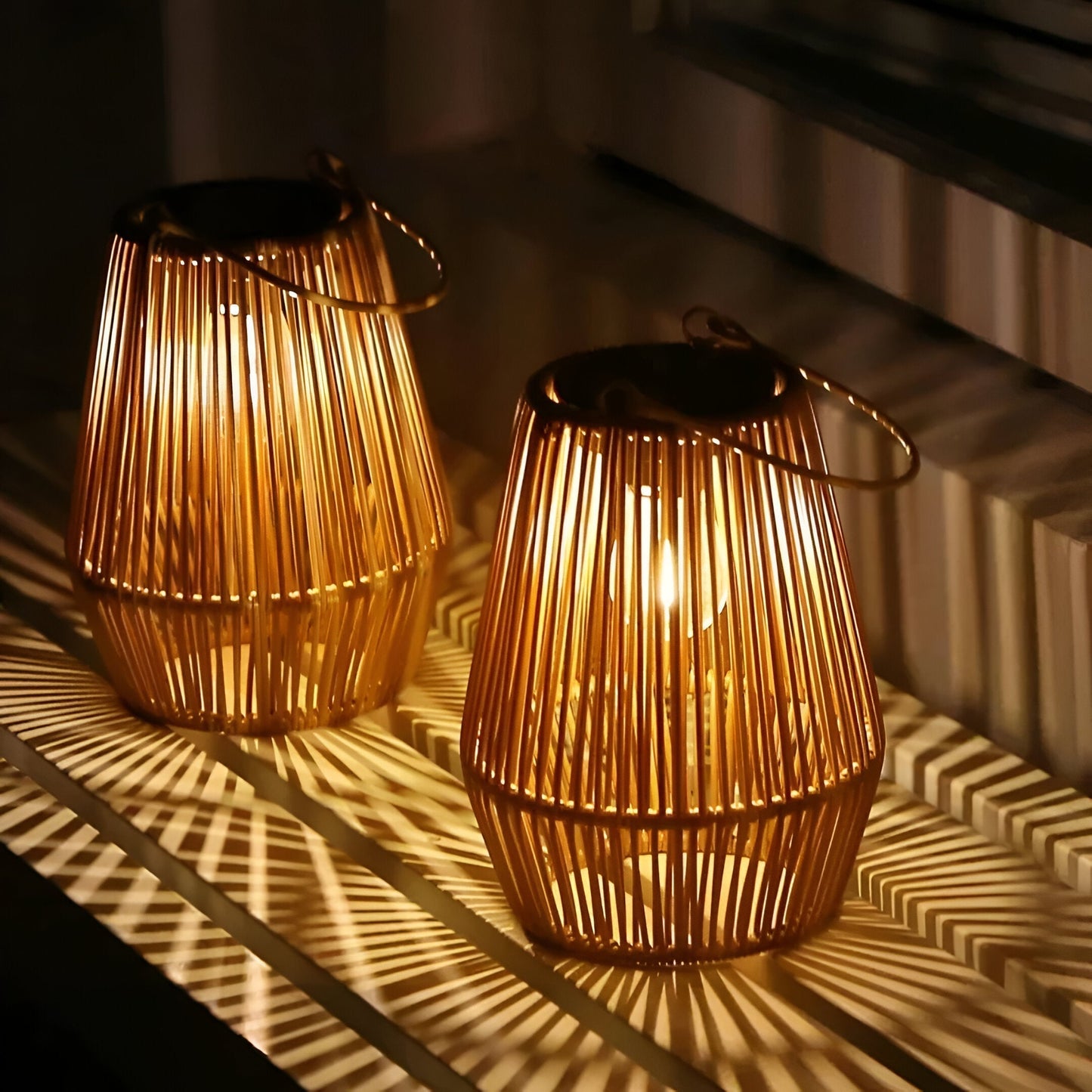 Two glowing tan bamboo cage lanterns with solar tops, casting decorative light patterns on a surface at night.