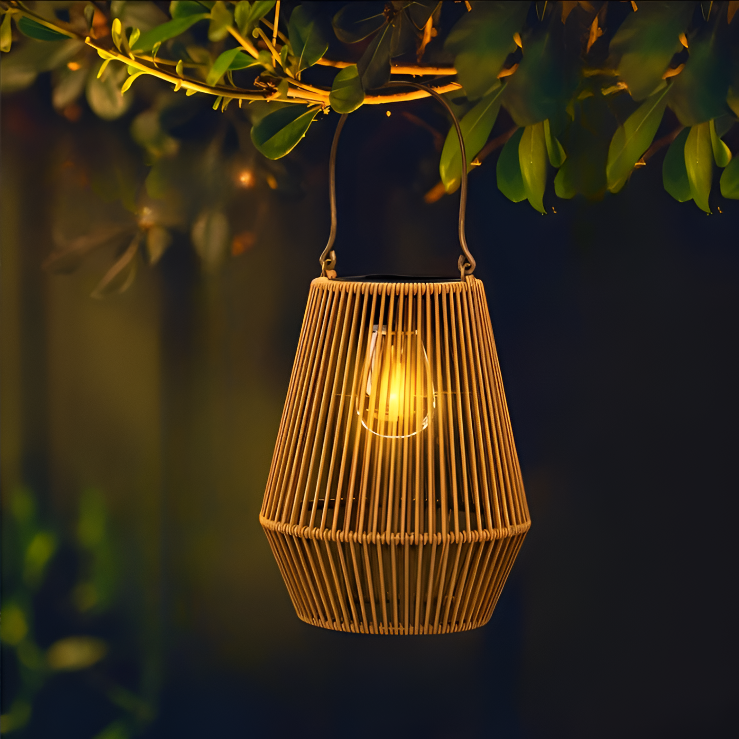 Fitlybuy CageRattan solar garden lantern with a warm glow, hanging from a tree branch in a dark outdoor setting.
