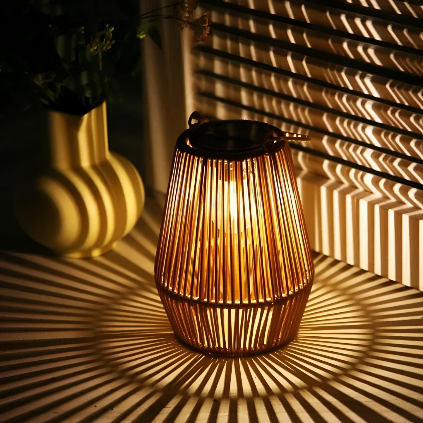 Fitlybuy bamboo solar lantern glowing on a table, casting geometric shadows in a cozy, warm-lit indoor setting.