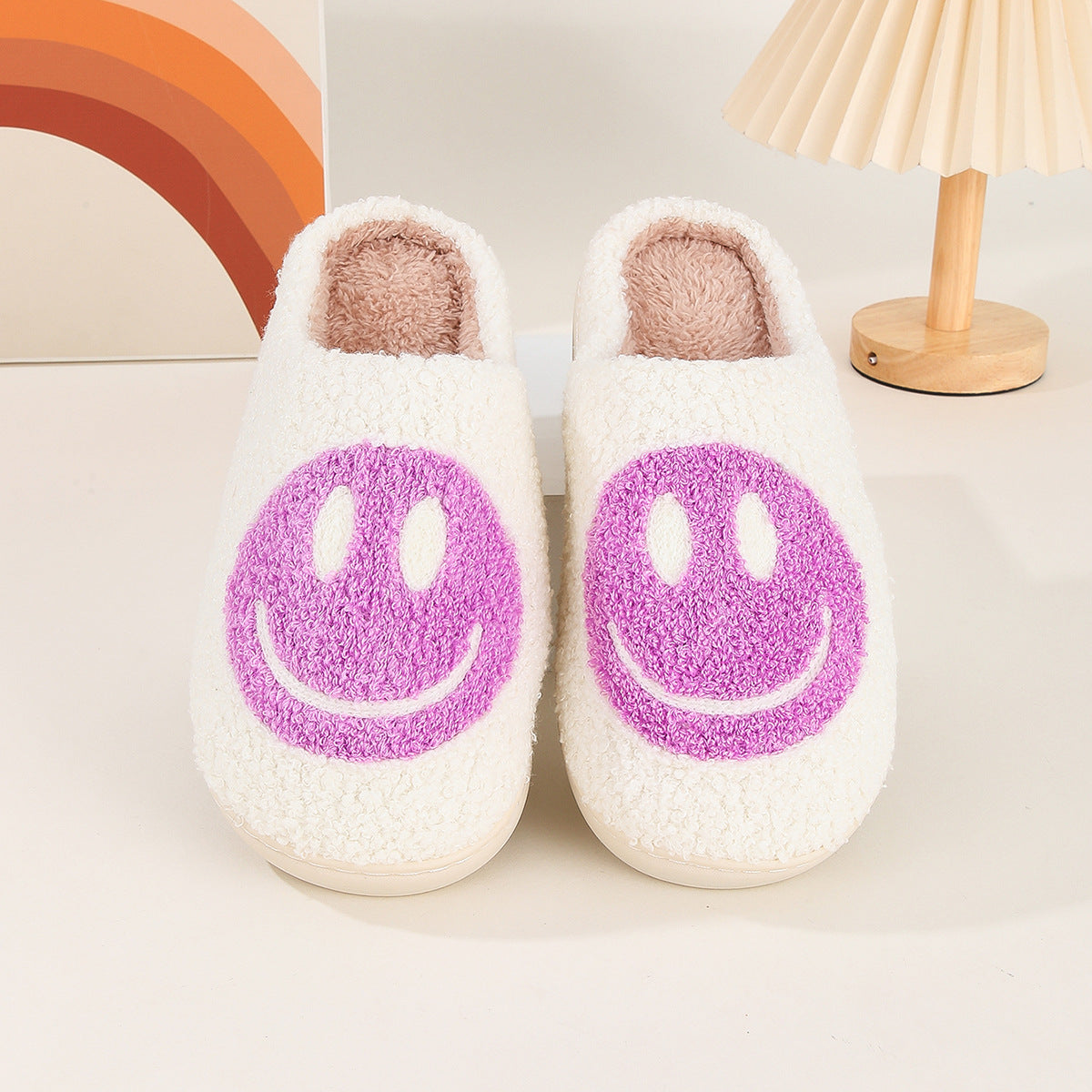 Fitlybuy Nordic plush white slippers with purple smiley faces and memory foam cushioning on a neutral desk background.