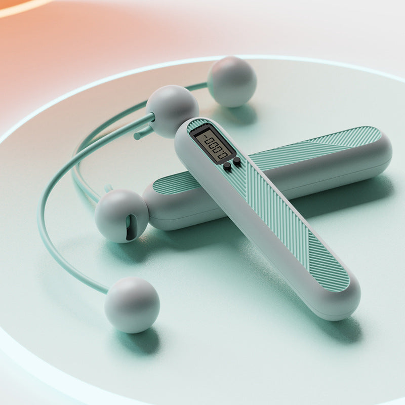Fitlybuy cordless digital jump rope in mint green with a built-in LCD tracker display, resting on a matching surface.