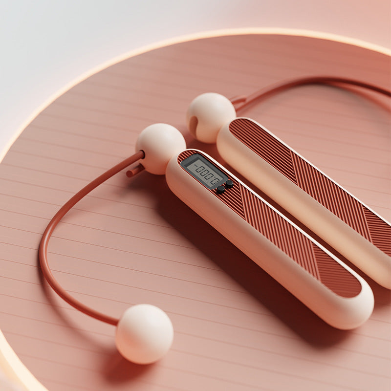 Fitlybuy cordless digital skipping rope with a smart tracking display, in terracotta and cream on a circular surface.