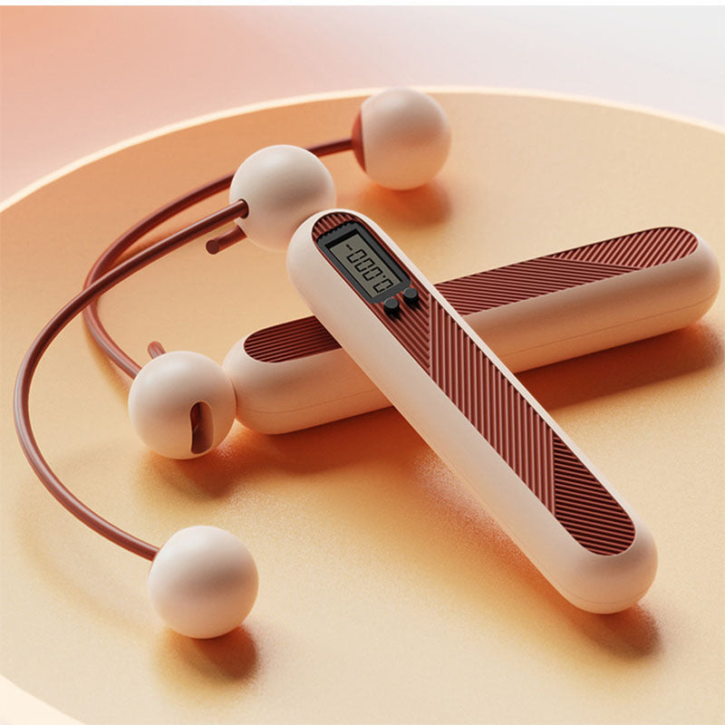 Fitlybuy cordless digital skipping rope in beige and brown, featuring an LCD display, resting on a round golden tray.