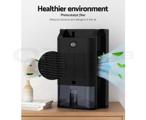 Black Fitlybuy 2L dehumidifier and air purifier with photocatalyst filter, sitting on a wooden surface.