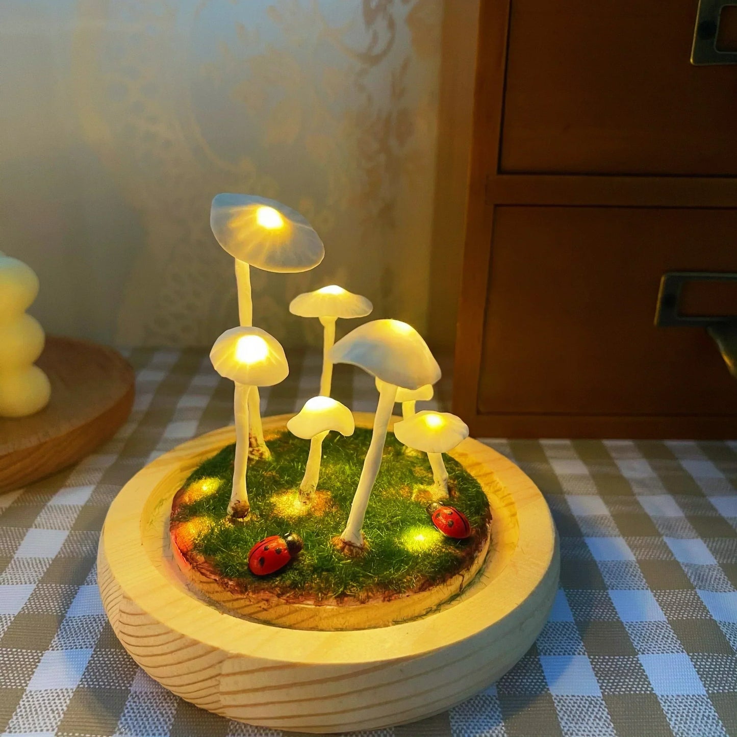 Fitlybuy Enchanted Mushroom DIY Lamp with glowing white caps, mossy base, and ladybugs on a checkered table.