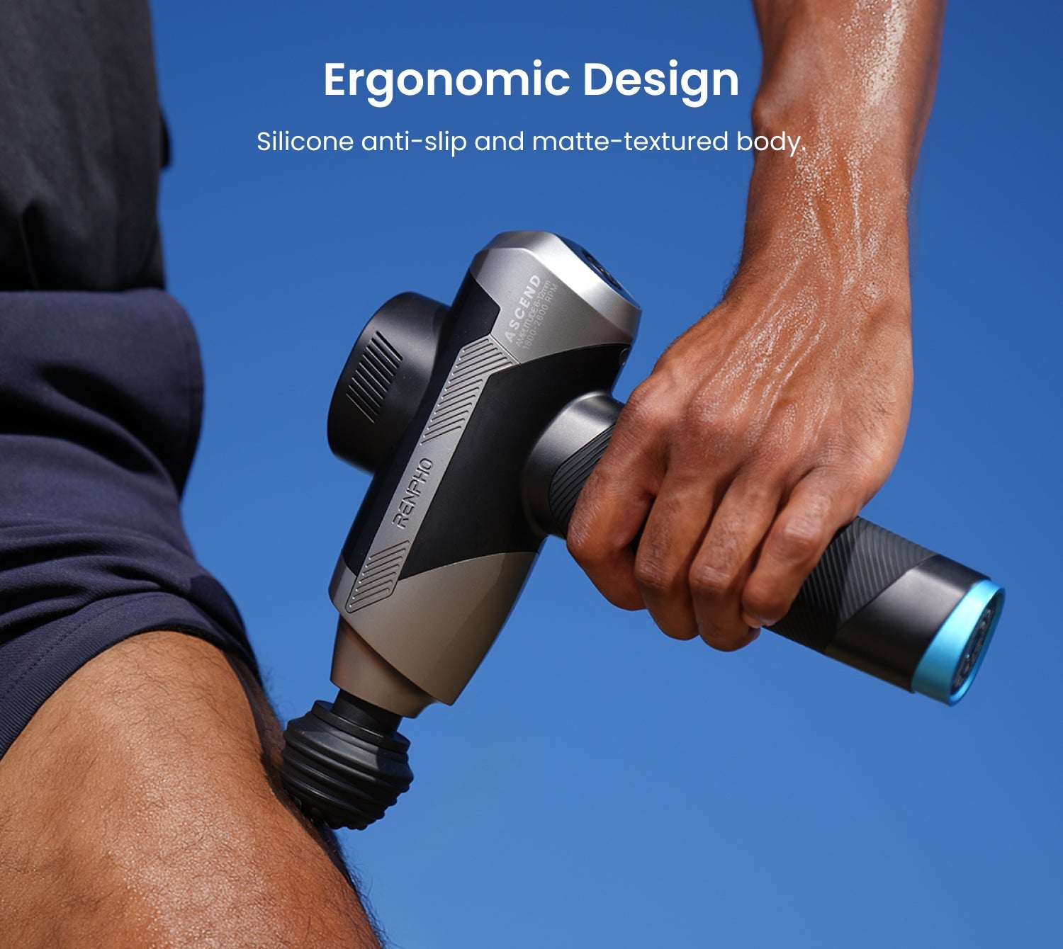Fitlybuy Ascend black and grey massage gun with matte-textured body being used on a leg against a blue background.