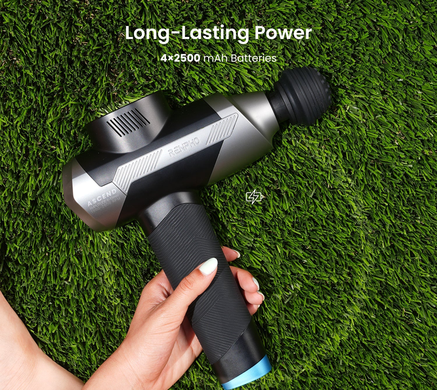 Black and silver Fitlybuy Ascend massage gun held over green grass, highlighting HyperPulse battery power.