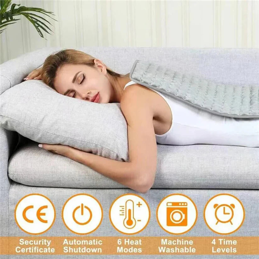Gray Fitlybuy heated therapy pad on a woman's back while she rests on a sofa, featuring 6 heat and 4 time settings.