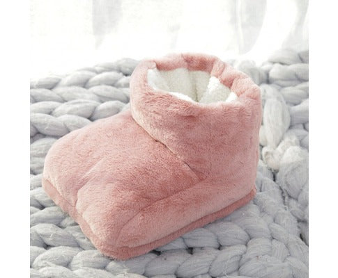 Fitlybuy pink plush electric heated foot warmer with white lining resting on a chunky gray knit blanket.