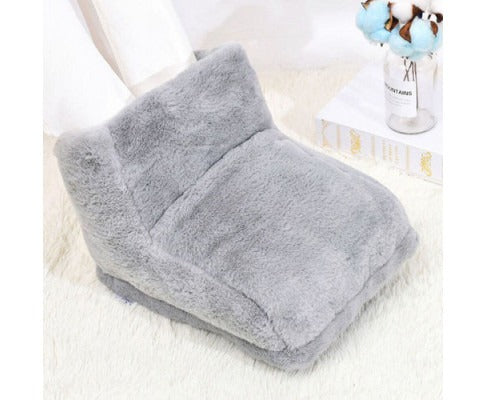 Grey plush Fitlybuy electric heated foot warmer on a white rug with a decorative vase in the background.