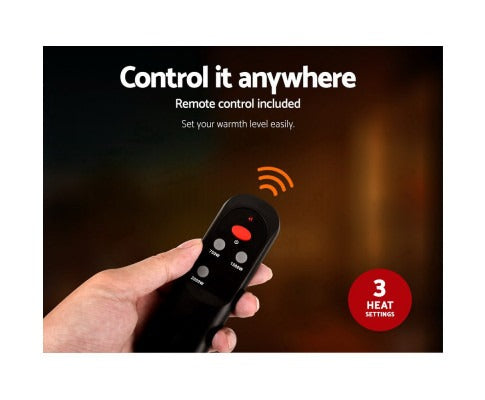 Hand holding a black Fitlybuy 2000W infrared heater remote with three power settings and signal indicator.