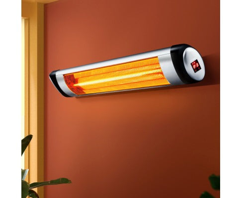 Fitlybuy wall-mounted electric strip heater with glowing orange radiant elements and a digital display on a red wall.