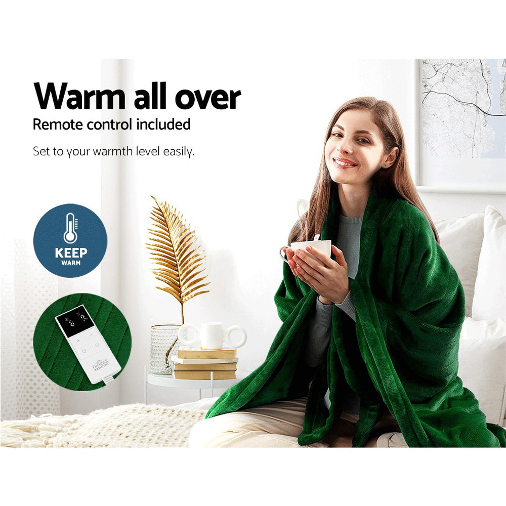 Woman wrapped in a green Fitlybuy electric throw rug with a handheld remote control for adjustable warmth settings.