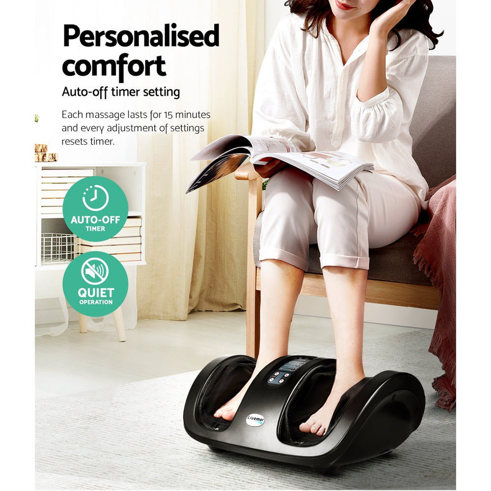 A person uses a black Livemor foot massager with deep tissue technology while sitting in a cozy home setting.