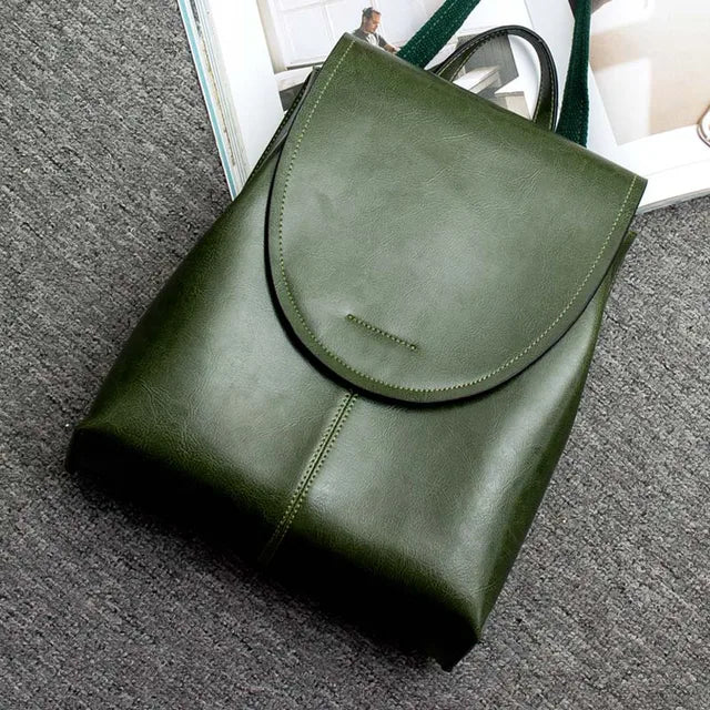 Fitlybuy olive green leather backpack with a flap top and durable construction, resting on a textured gray surface.