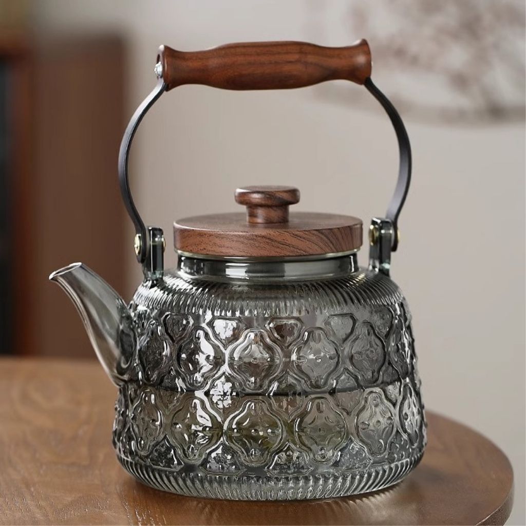 Fitlybuy Zoie glass teapot with textured grey borosilicate glass, wooden lid, and handle, sitting on a wooden table.