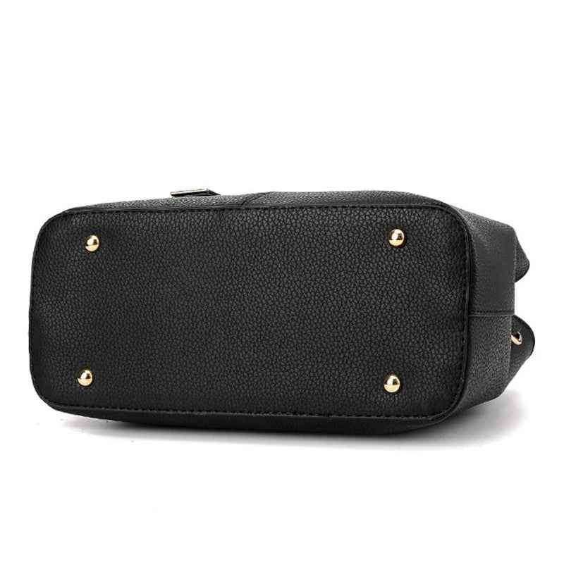 Bottom view of a black, textured PU leather Fitlybuy handbag with four gold protective metal feet.