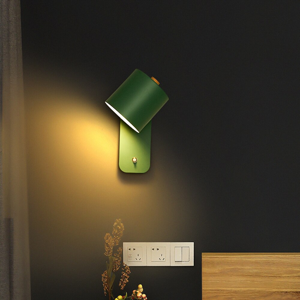 Modern green LED wall light with integrated smart switch, mounted on a dark wall, emitting a warm glowing light.