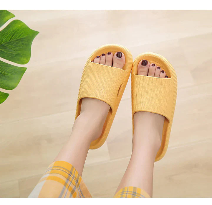 Fitlybuy yellow Cloud Slides featuring a textured strap and ComfortFoam cushioning, worn indoors on a wooden floor.