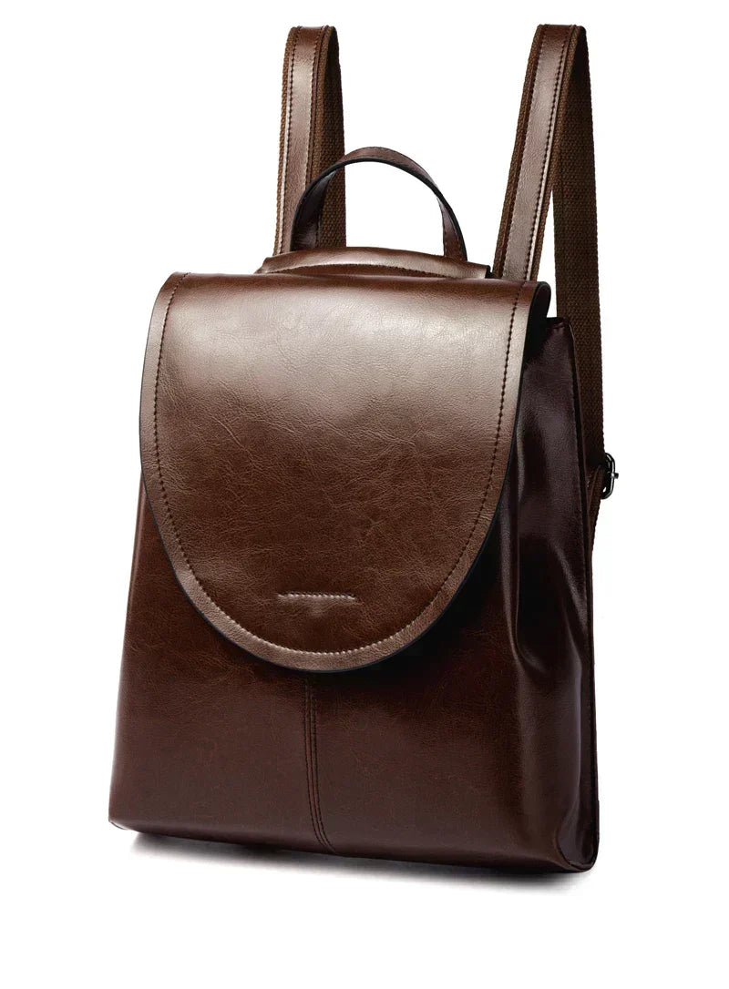 Trendy dark brown leather backpack with a flap cover, top handle, and adjustable shoulder straps against a white background.